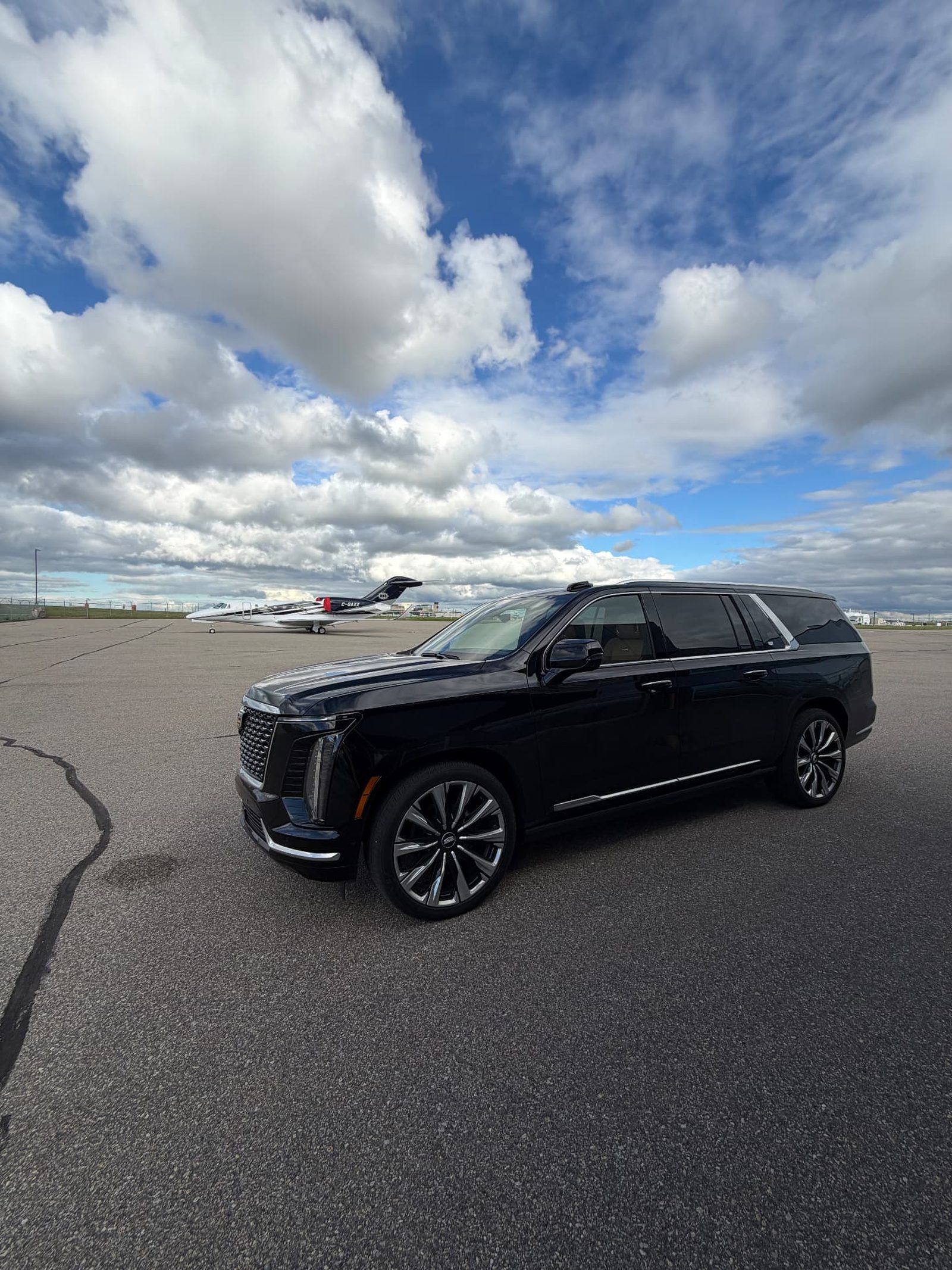 Excellence Limo Cadillac Escalade beside a private jet